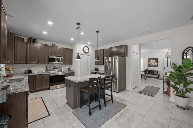 811 Sandstone Dr, Saint Augustine, FL 32086 - kitchen featuring visible vents, a sink, stainless steel appliances, light stone countertops, and dark brown cabinets