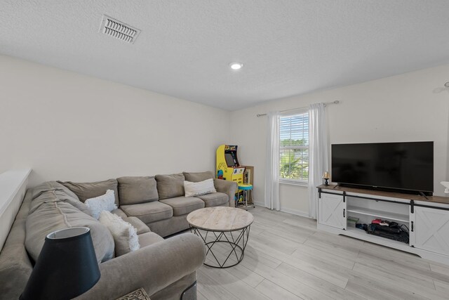 811 Sandstone Dr, Saint Augustine, FL 32086 - living area featuring baseboards, visible vents, light wood finished floors, and a textured ceiling