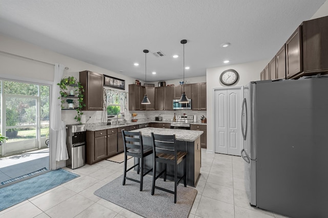 811 Sandstone Dr, Saint Augustine, FL 32086 - kitchen featuring tasteful backsplash, visible vents, dark brown cabinets, light tile patterned floors, and stainless steel appliances