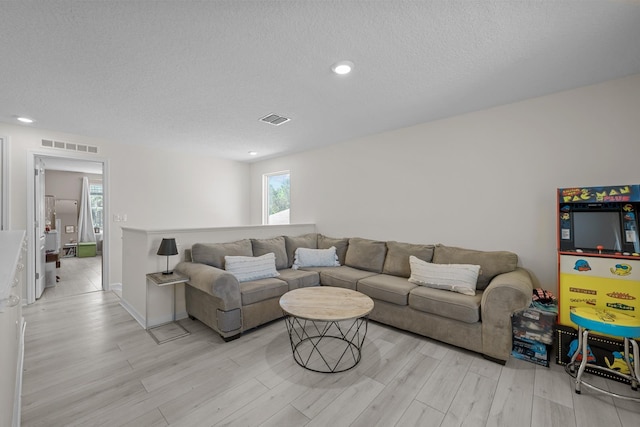 811 Sandstone Dr, Saint Augustine, FL 32086 - living room with visible vents, light wood-style flooring, and a textured ceiling