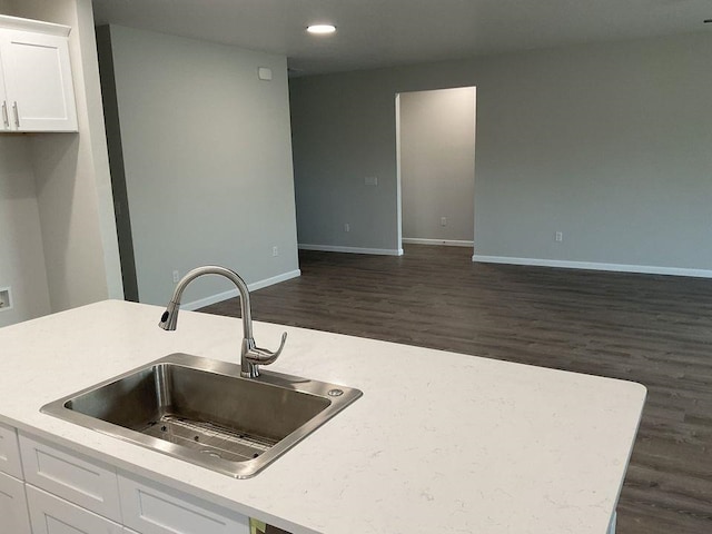 kitchen featuring dark hardwood / wood-style flooring, white cabinetry, and sink