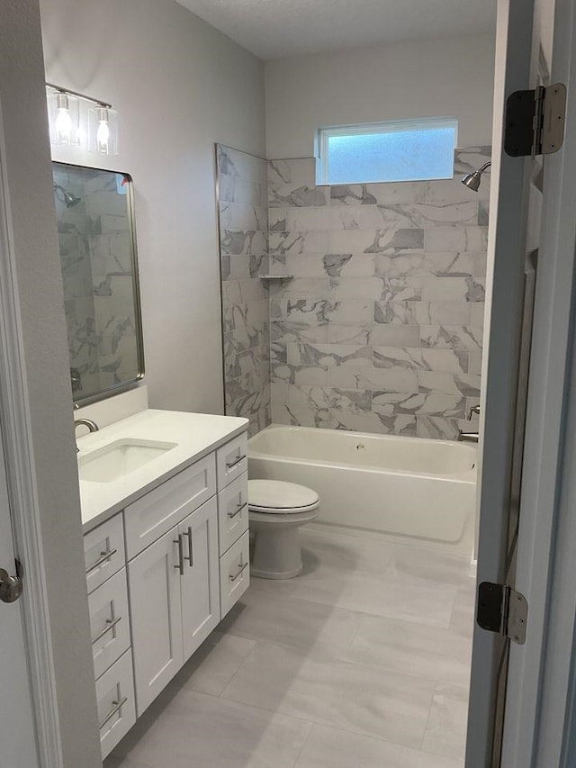 full bathroom featuring toilet, vanity, and tiled shower / bath