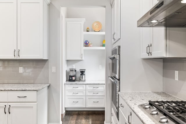 kitchen featuring white cabinetry, dark hardwood / wood-style flooring, extractor fan, and appliances with stainless steel finishes