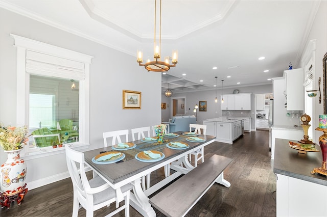 dining area with sink, dark wood-type flooring, a raised ceiling, a notable chandelier, and crown molding