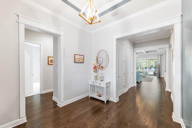 corridor with dark hardwood / wood-style flooring, ornamental molding, and an inviting chandelier