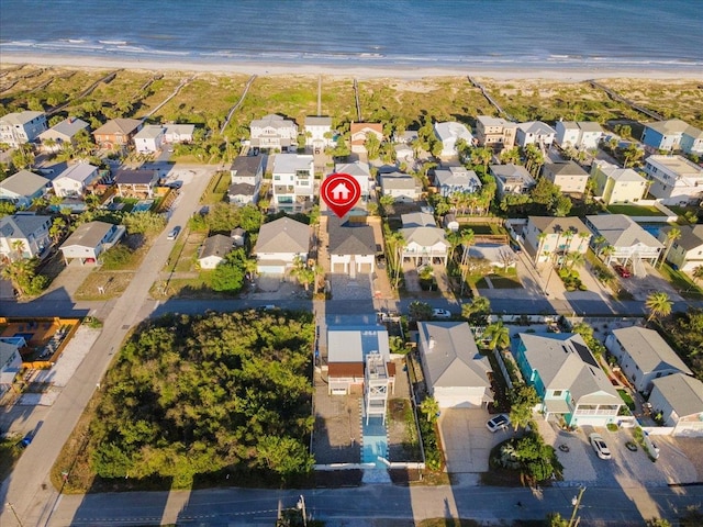 drone / aerial view with a beach view, a residential view, and a water view