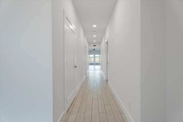 hall with recessed lighting, light wood-type flooring, and baseboards