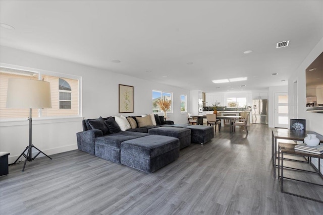 living area featuring visible vents, recessed lighting, baseboards, and wood finished floors