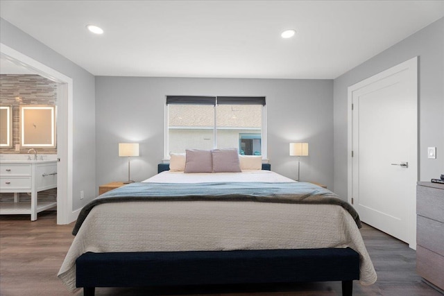 bedroom featuring recessed lighting, wood finished floors, baseboards, and connected bathroom