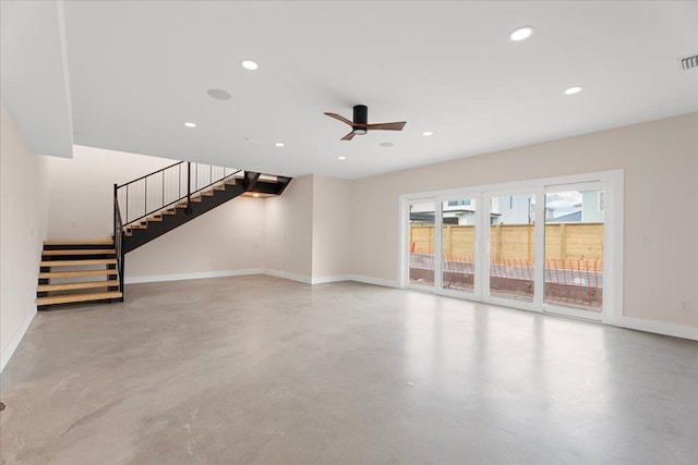 unfurnished living room featuring finished concrete flooring, recessed lighting, stairway, baseboards, and ceiling fan