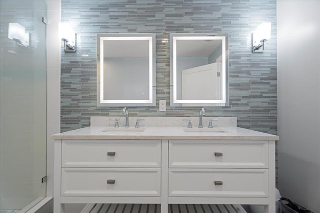 full bathroom featuring a sink, backsplash, double vanity, and a tile shower