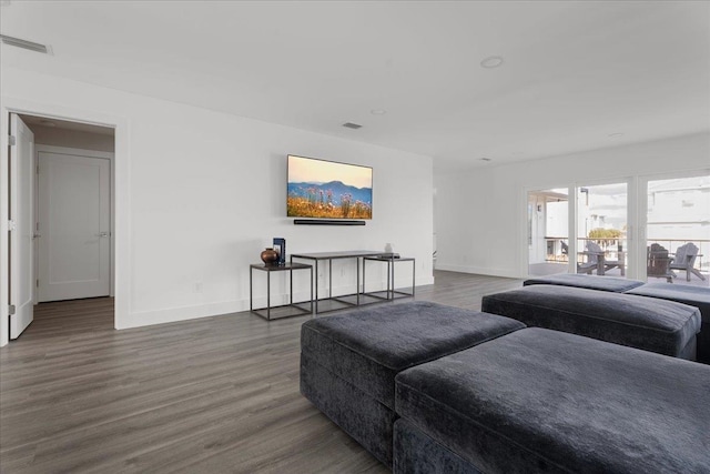 living area with visible vents, baseboards, and wood finished floors