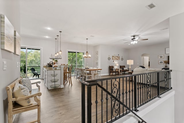 121 Grand Ravine Dr, Saint Augustine, FL 32086 - hall featuring wood finished floors, a chandelier, recessed lighting, and arched walkways