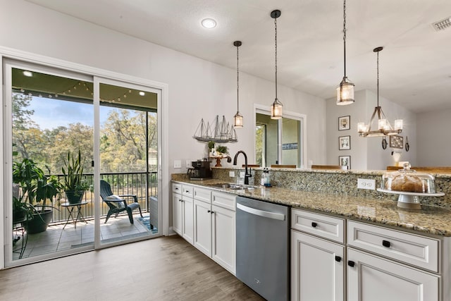 121 Grand Ravine Dr, Saint Augustine, FL 32086 - kitchen featuring stainless steel dishwasher, a sink, light stone counters, white cabinetry, and recessed lighting