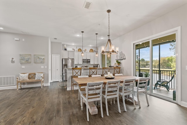 121 Grand Ravine Dr, Saint Augustine, FL 32086 - dining room featuring dark wood finished floors, recessed lighting, a chandelier, baseboards, and a water view
