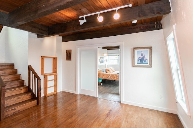 spare room featuring wood-type flooring, wood ceiling, beamed ceiling, and rail lighting