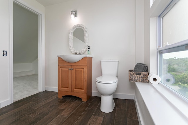 bathroom with a healthy amount of sunlight, vanity, and toilet