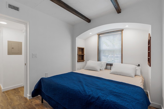 bedroom with electric panel, hardwood / wood-style floors, and beamed ceiling