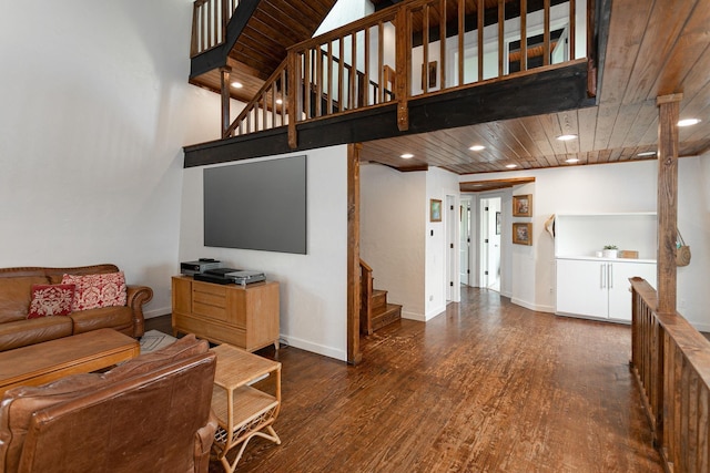 living room featuring wood ceiling, dark hardwood / wood-style flooring, and a towering ceiling