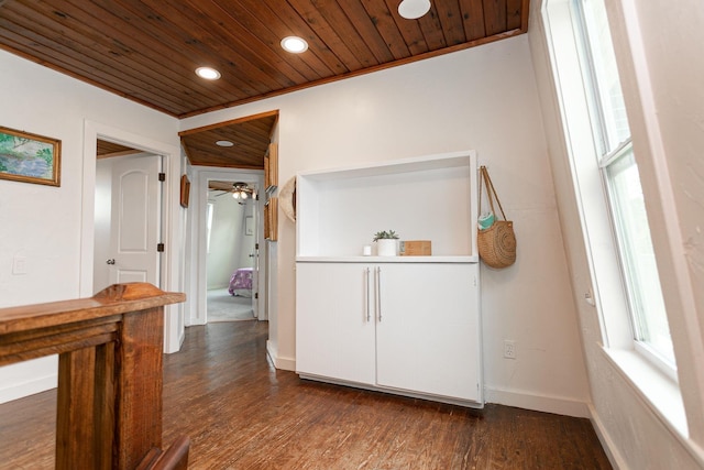 corridor featuring dark wood-type flooring, wooden ceiling, and crown molding