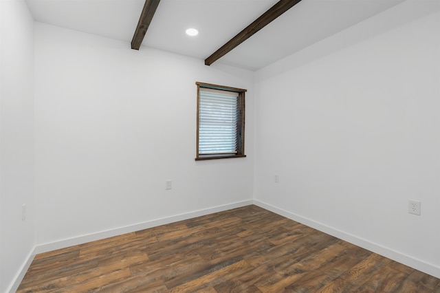 spare room with dark wood-type flooring and beamed ceiling