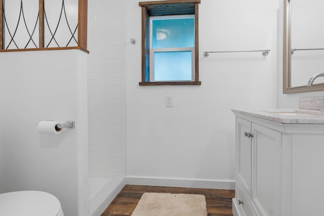 bathroom featuring toilet, a shower, wood-type flooring, and vanity