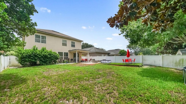 rear view of house featuring a yard and a patio area