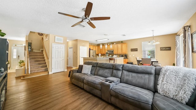 living room featuring a textured ceiling, ceiling fan, and dark hardwood / wood-style floors