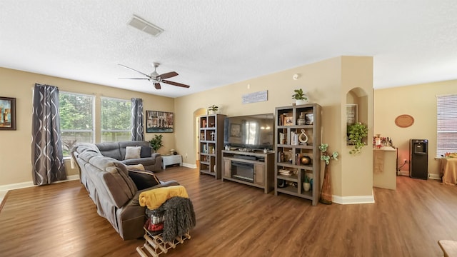 living room with ceiling fan, wood-type flooring, and a textured ceiling