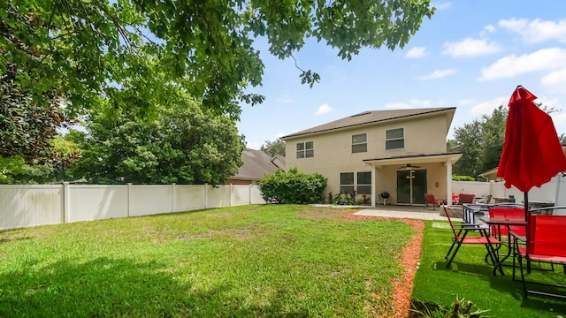 rear view of house with a yard, a patio, and ceiling fan