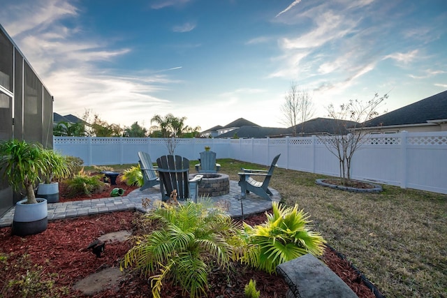 view of yard featuring glass enclosure, an outdoor fire pit, and a patio area