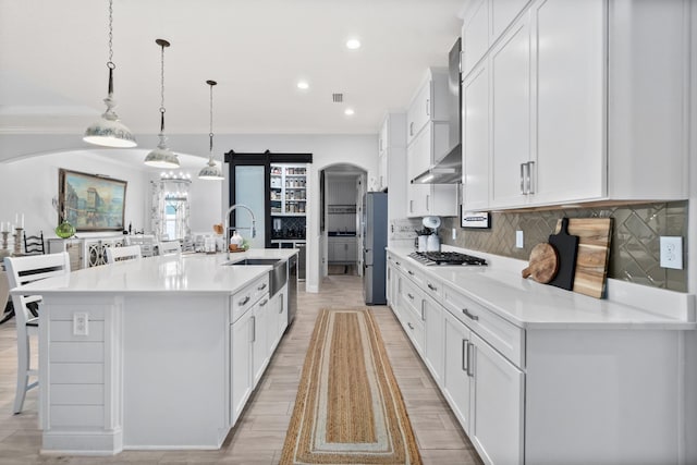 kitchen featuring a kitchen bar, tasteful backsplash, a spacious island, hanging light fixtures, and stainless steel appliances