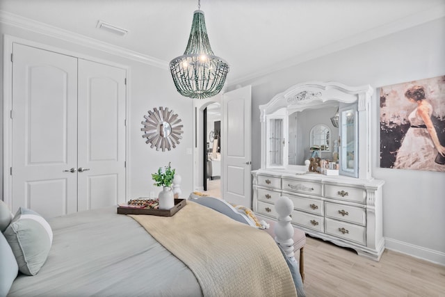 bedroom featuring light hardwood / wood-style floors, a closet, a notable chandelier, and ornamental molding