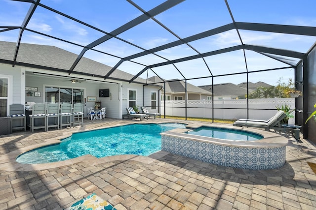 view of pool featuring an in ground hot tub, a patio area, and glass enclosure