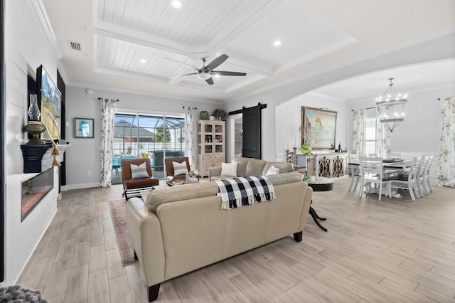 living room with a barn door, ceiling fan with notable chandelier, a large fireplace, coffered ceiling, and beamed ceiling