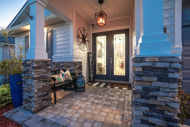 property entrance featuring covered porch and french doors