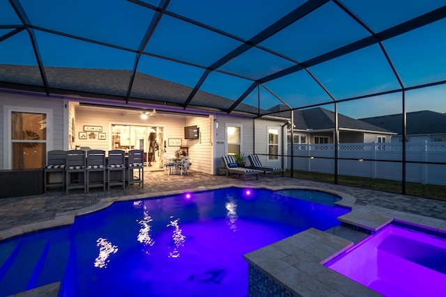 view of pool featuring exterior bar, an in ground hot tub, a patio area, and a lanai