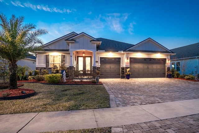 view of front of house featuring a garage, a front yard, and french doors