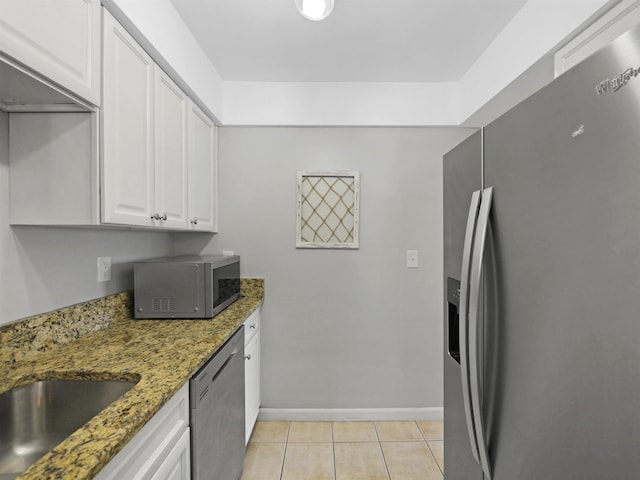 129 Rio Del Mar St Unit C, Saint Augustine, FL 32080 - kitchen with stainless steel appliances, white cabinetry, light tile patterned floors, baseboards, and light stone counters
