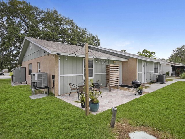 129 Rio Del Mar St Unit C, Saint Augustine, FL 32080 - rear view of house with roof with shingles, central air condition unit, a patio, and a yard