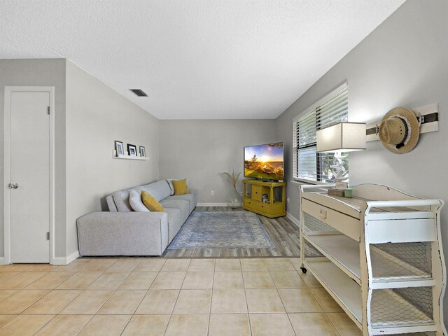 129 Rio Del Mar St Unit C, Saint Augustine, FL 32080 - living area with light tile patterned floors, a textured ceiling, and baseboards