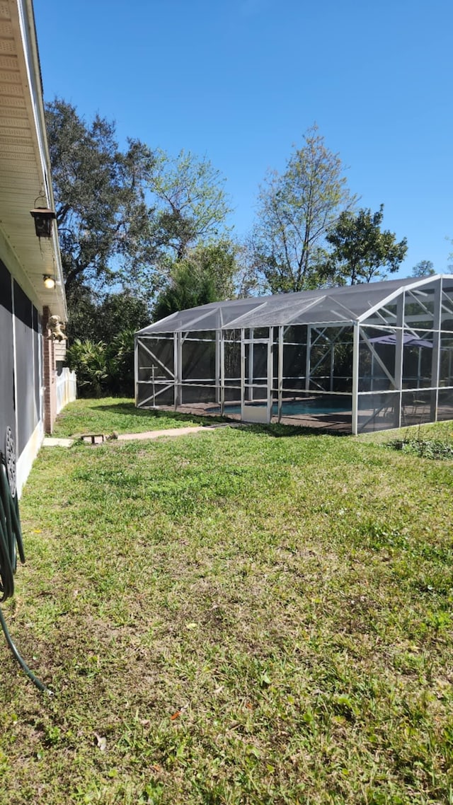 view of yard with a lanai and a swimming pool