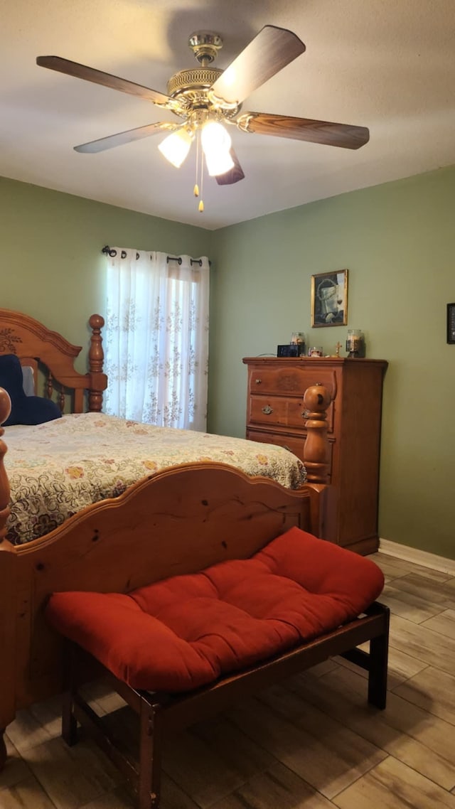 bedroom with light wood finished floors, baseboards, and a ceiling fan