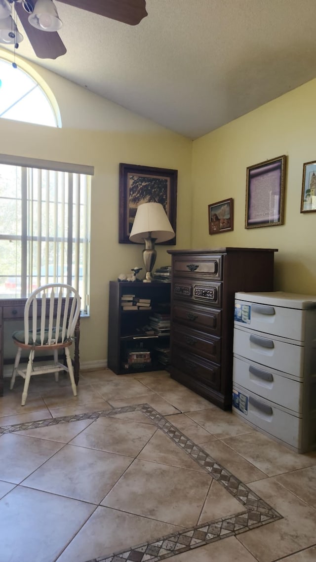 tiled home office with ceiling fan and vaulted ceiling