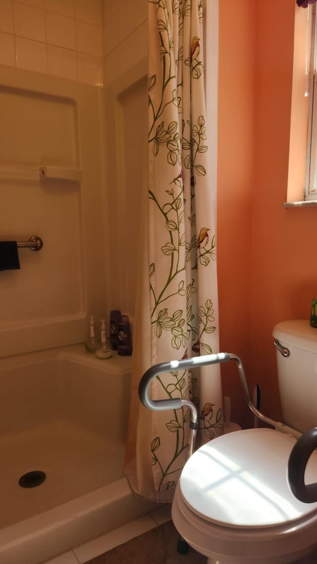 full bathroom with toilet, a shower stall, and tile patterned flooring