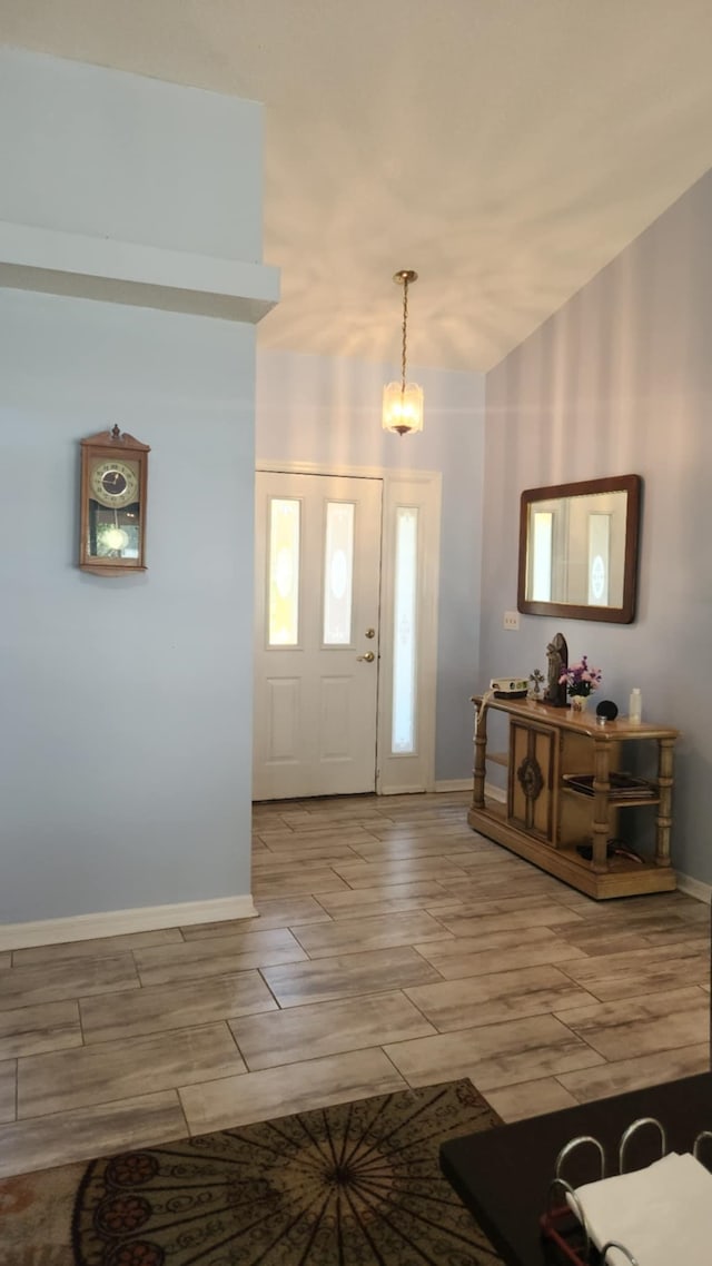 foyer entrance with baseboards and wood tiled floor