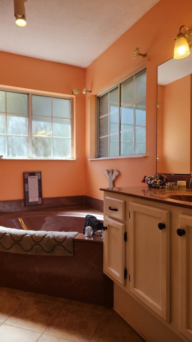 full bathroom with vanity, a garden tub, and tile patterned flooring