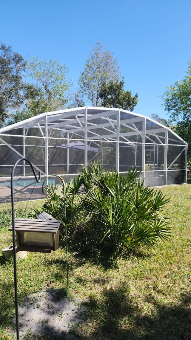 exterior space featuring glass enclosure and an outdoor pool