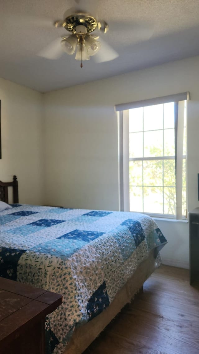 bedroom featuring a ceiling fan and wood finished floors