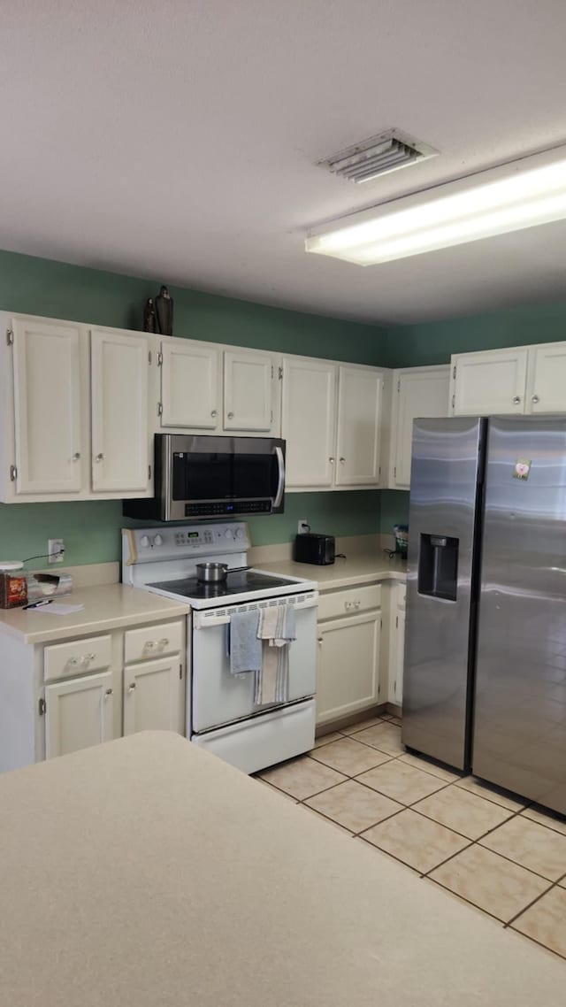 kitchen with white cabinets, appliances with stainless steel finishes, and light countertops